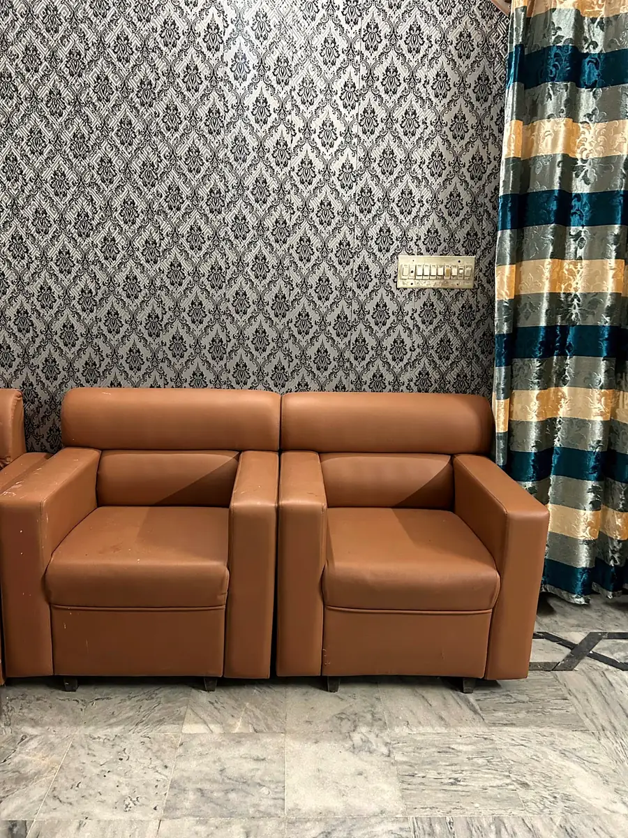 Caramel sofa against patterned wallpaper